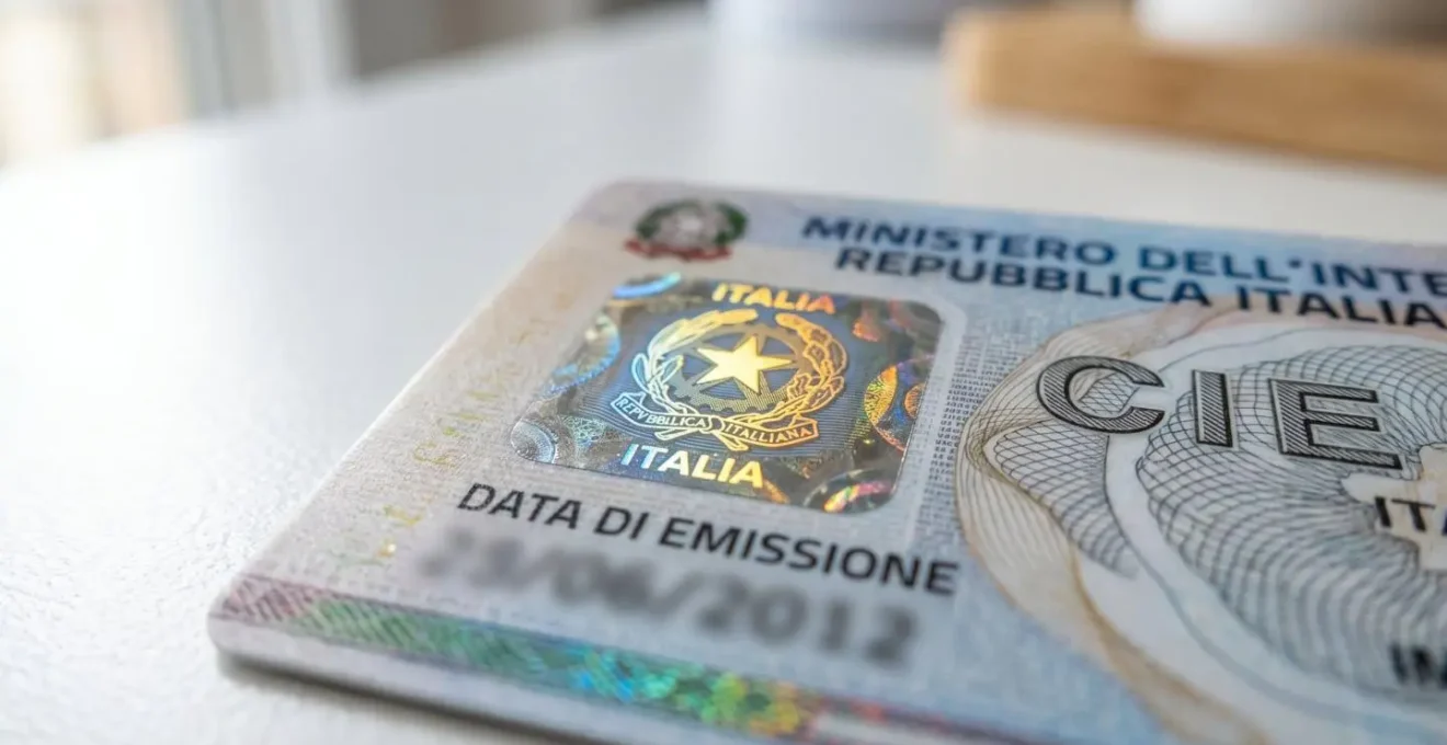 Dettaglio ravvicinato di una carta d'identità elettronica italiana appoggiata su superficie bianca con focus sull'ologramma di sicurezza
